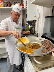 Chef Bayram preparing food in a professional kitchen